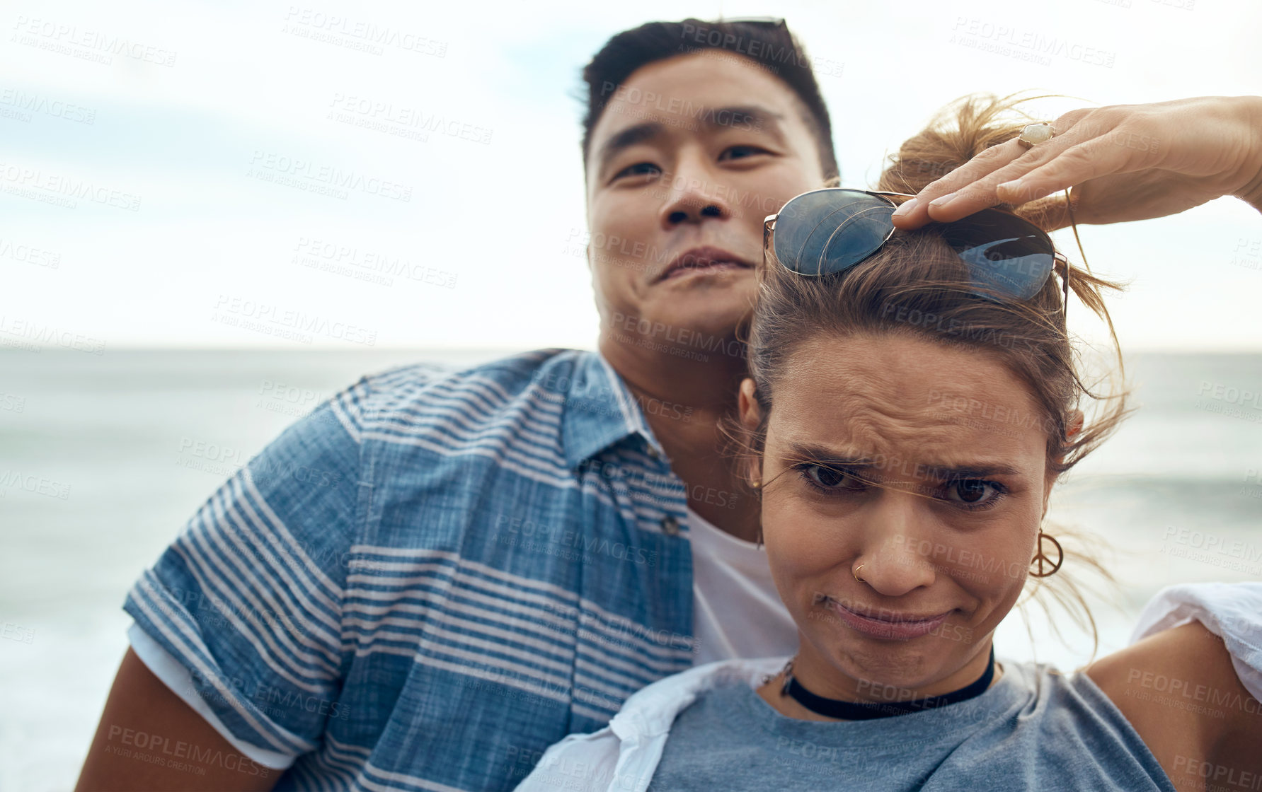 Buy stock photo Portrait of a happy young couple making funny faces on a vacation along the coast