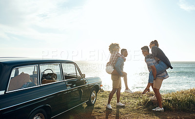 Buy stock photo Shot of a group of happy young friends having fun on a road trip along the coast