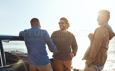 Buy stock photo Shot of a group of happy young friends enjoying a road trip along the coast