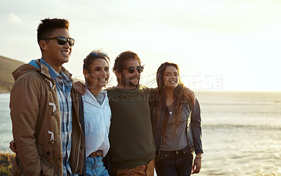 Buy stock photo Shot of a group of happy young friends enjoying a vacation along the coast