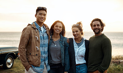 Buy stock photo Shot of a group of happy young friends enjoying a road trip along the coast