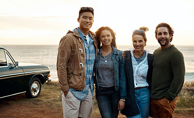Buy stock photo Shot of a group of happy young friends enjoying a road trip along the coast
