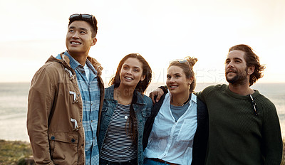 Buy stock photo Shot of a group of happy young friends enjoying a vacation along the coast