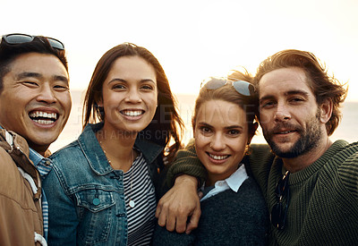 Buy stock photo Shot of a group of happy young friends hanging out together outdoors