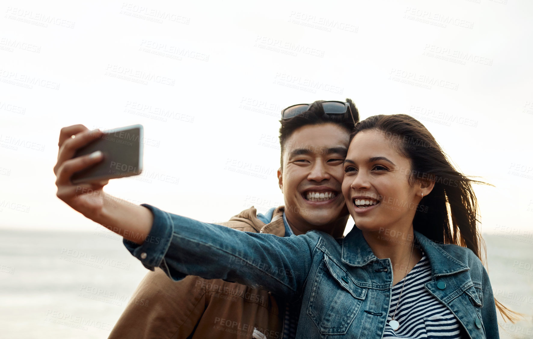 Buy stock photo Date, selfie and smile with couple at beach for social media post, romantic getaway and bonding. Connection, love and photography with man and woman outdoor for honeymoon holiday, marriage and travel