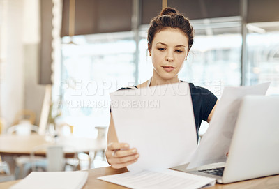 Buy stock photo Shot of a young cafe owner using her laptop and doing paperwork in her shop