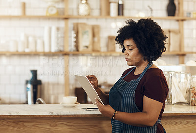 Buy stock photo Shot of a coffee owner using a digital tablet while standing in her cafe