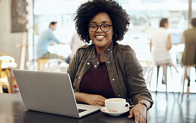 Buy stock photo Cropped shot of a young woman enjoying a cup of coffee while using her laptop in a cafe
