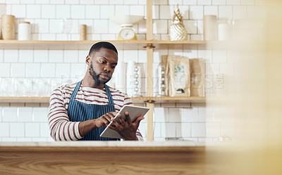 Buy stock photo Cropped shot of a young shop owner using a digital tablet in his cafe