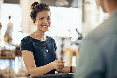 Buy stock photo Cropped shot of a young woman paying by card in a coffee shop