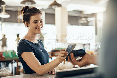 Buy stock photo Shot of a young woman making a payment using her cellphone in a cafe