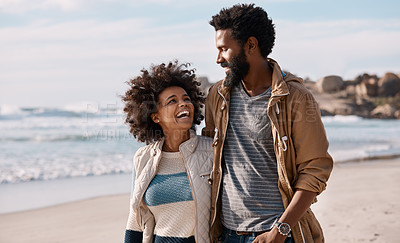 Buy stock photo Shot of a happy young couple going for a romantic walk along the beach