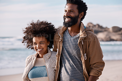 Buy stock photo Shot of a happy young couple going for a romantic walk along the beach