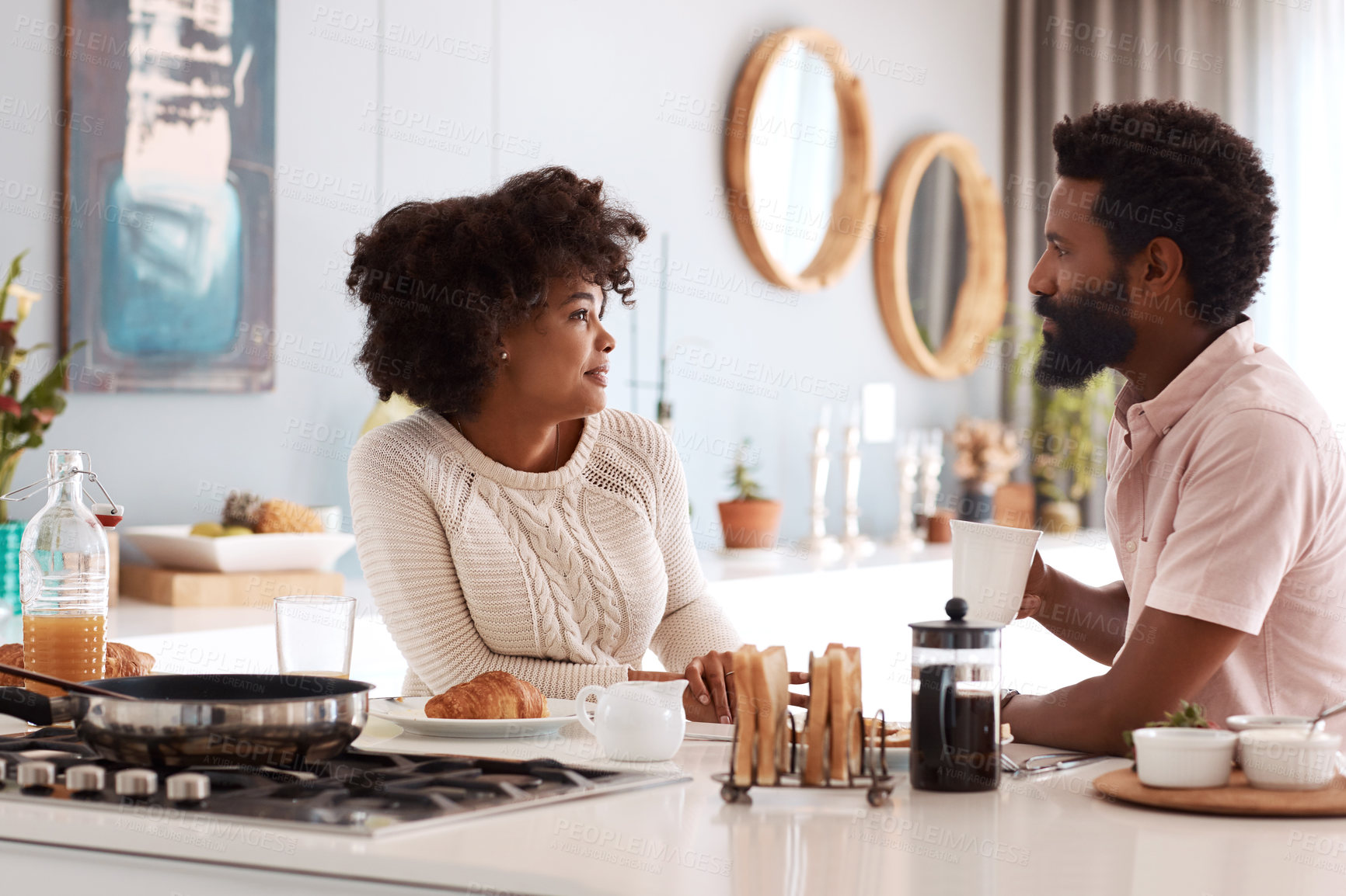 Buy stock photo Cropped shot of a couple having breakfast in their kitchen