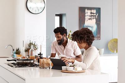 Buy stock photo Cropped shot of a couple using wireless devices while having breakfast in their kitchen