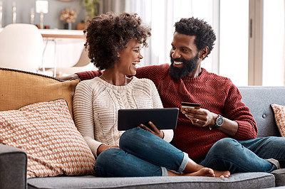 Buy stock photo Shot of a man holding a credit card while browsing on a digital tablet with his wife