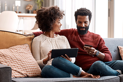Buy stock photo Shot of a man holding a credit card while browsing on a digital tablet with his wife