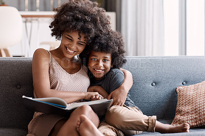 Buy stock photo Shot of an adorable little boy reading a book and spending time with his mother at home