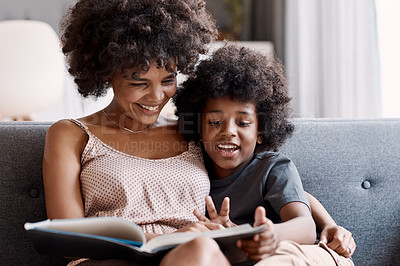 Buy stock photo Shot of an adorable little boy reading a book and spending time with his mother at home