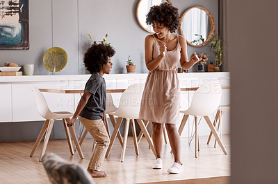 Buy stock photo Full length shot of a happy young mother and son dancing together at home
