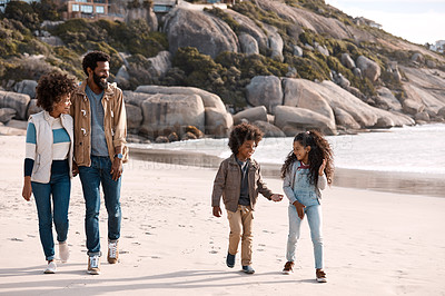 Buy stock photo Shot of an adorable little boy and girl going for a walk along the beach with their parents