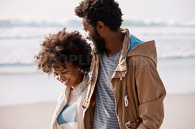 Buy stock photo Shot of a happy young couple going for a romantic walk along the beach