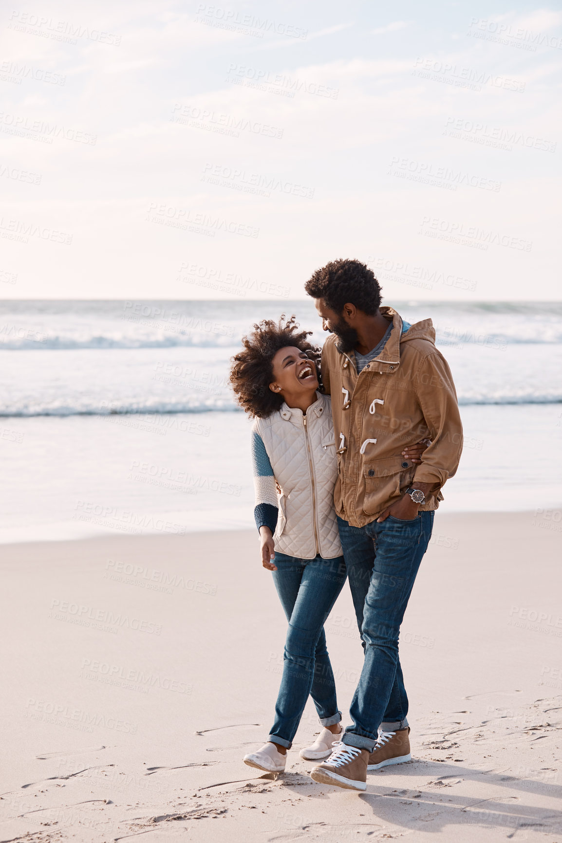 Buy stock photo Laughing, couple and walking on beach for travel, support or bonding with humor on coast. Black people, happiness and healthy relationship with space, connection and exploring on seaside stroll