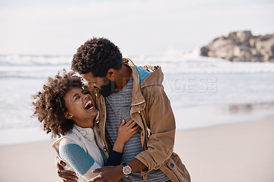 Buy stock photo Shot of a happy young couple going for a romantic walk along the beach
