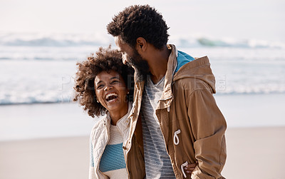 Buy stock photo Shot of a happy young couple going for a romantic walk along the beach