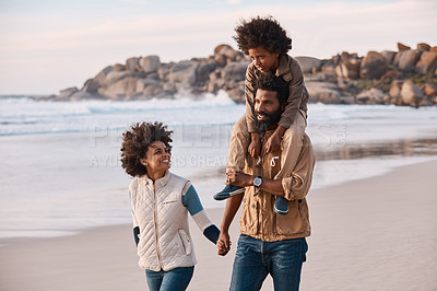 Buy stock photo Shot of a happy young family going for a walk along the beach