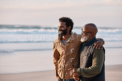 Buy stock photo Shot of a young man going for a walk along the beach with his father