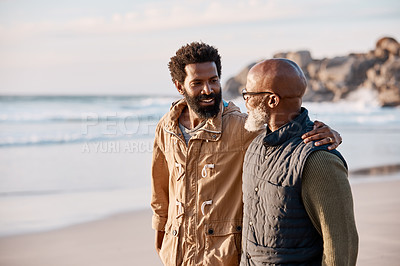 Buy stock photo Shot of a young man going for a walk along the beach with his father