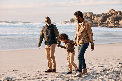 Buy stock photo Shot of an adorable little boy going for a walk along the beach with his grandfather and father