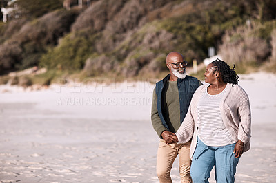 Buy stock photo Shot of a happy mature couple going for a romantic walk along the beach
