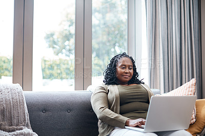 Buy stock photo Shot of a mature woman using a laptop at home