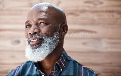 Buy stock photo Shot of a mature man looking thoughtful while standing against a brown background