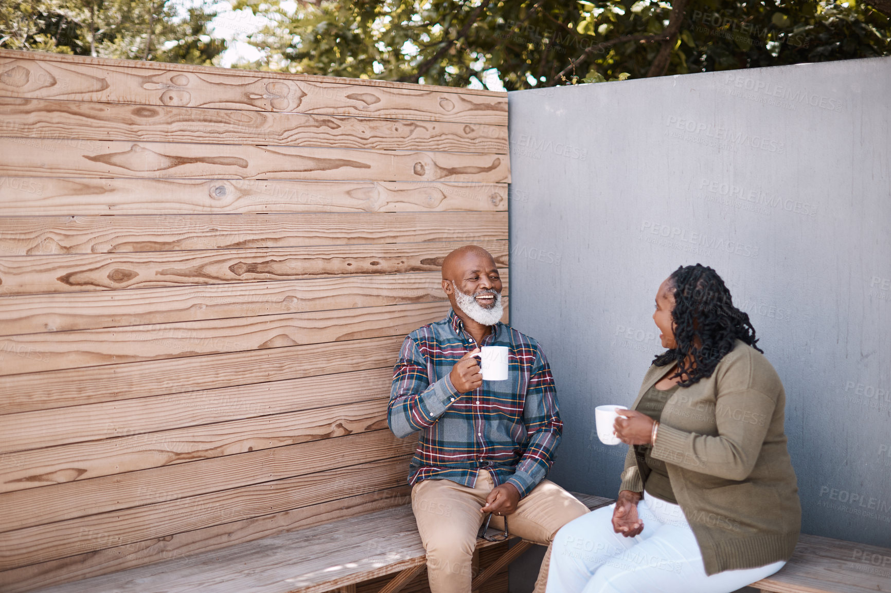 Buy stock photo Shot of a mature couple drinking coffee while having a chat outdoors