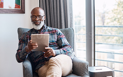 Buy stock photo Shot of a mature man using a digital tablet at home