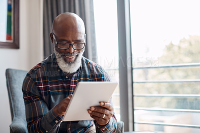 Buy stock photo Shot of a mature man using a digital tablet at home