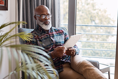 Buy stock photo Shot of a mature man using a digital tablet at home