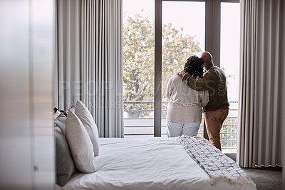 Buy stock photo Rearview shot of a mature couple looking through a window in a bedroom at home