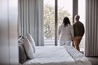 Buy stock photo Rearview shot of a mature couple looking through a window in a bedroom at home