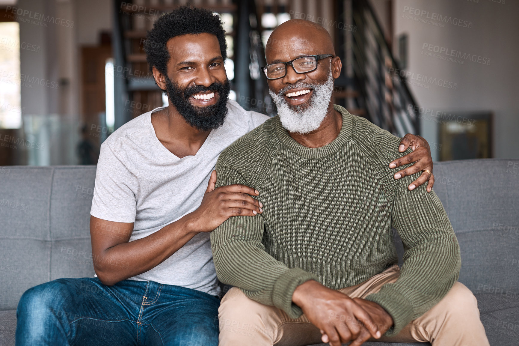 Buy stock photo Portrait of a happy young man relaxing and spending time with his father at home