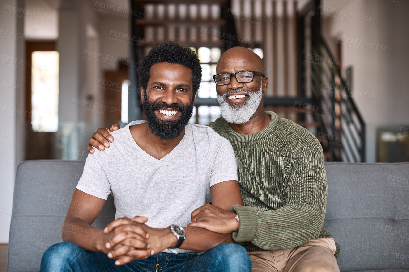 Buy stock photo Portrait of a happy young man relaxing and spending time with his father at home