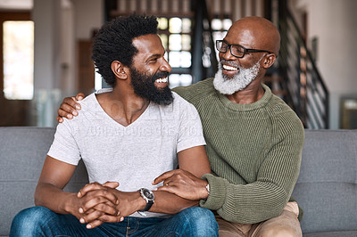 Buy stock photo Shot of a happy young man relaxing and spending time with his father at home