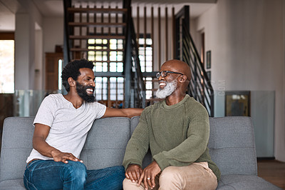 Buy stock photo Shot of a happy young man relaxing and spending time with his father at home