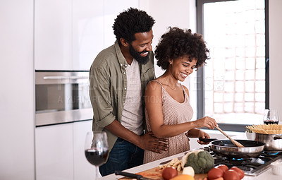 Buy stock photo Shot of a man embracing his wife while she cooks