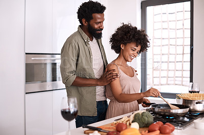 Buy stock photo Shot of a man embracing his wife while she cooks