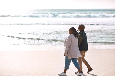 Buy stock photo Shot of a happy mature couple going for a romantic walk along the beach