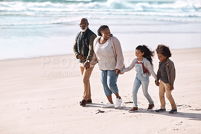 Buy stock photo Shot of an adorable little boy and girl going for a walk along the beach with their grandparents